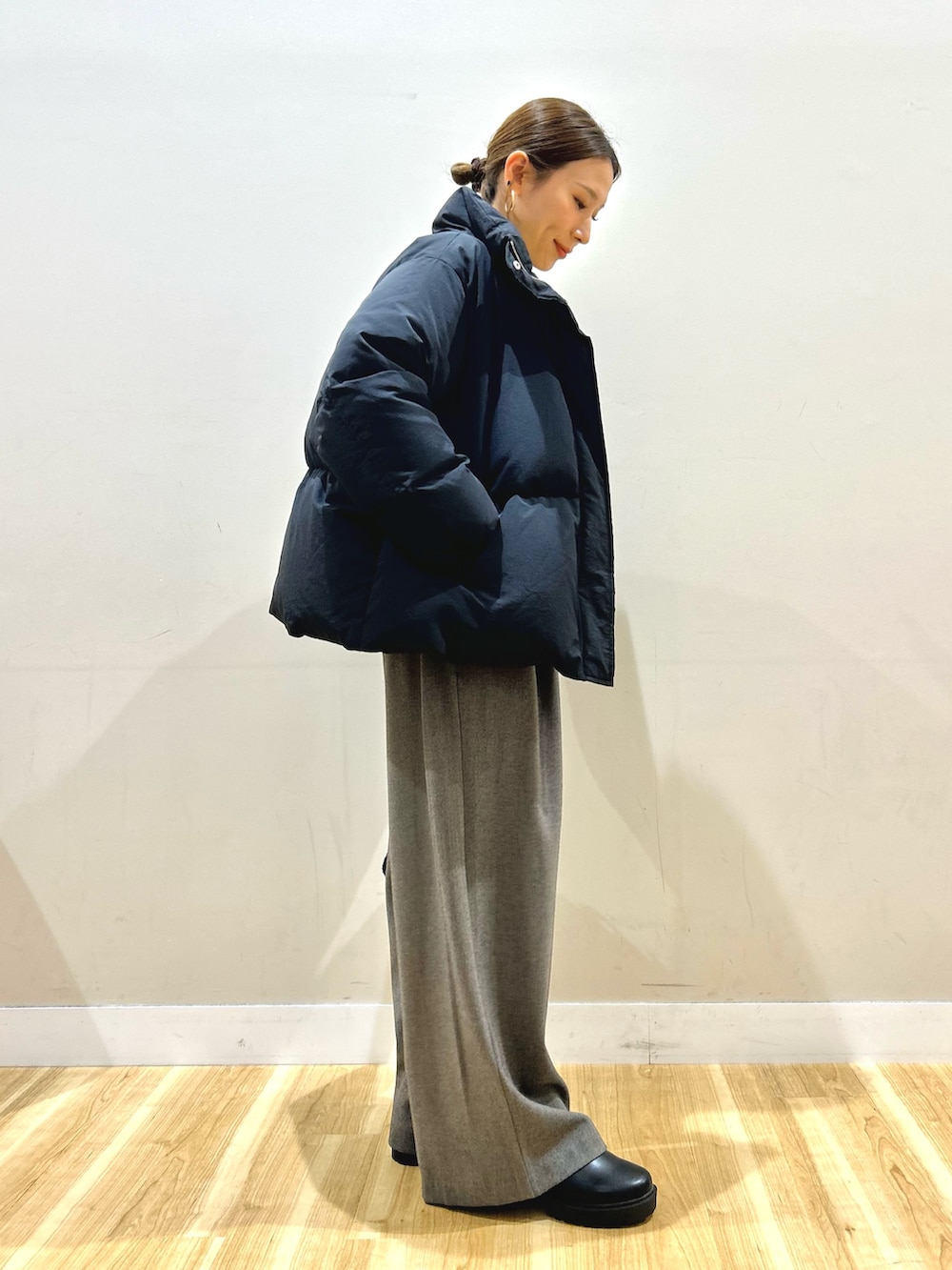 ブラック系のダウンジャケット/コート、ホワイト系のTシャツ/カットソー、ブラック系のブーツを着用したレディースの冬コーディネートの4枚目の写真