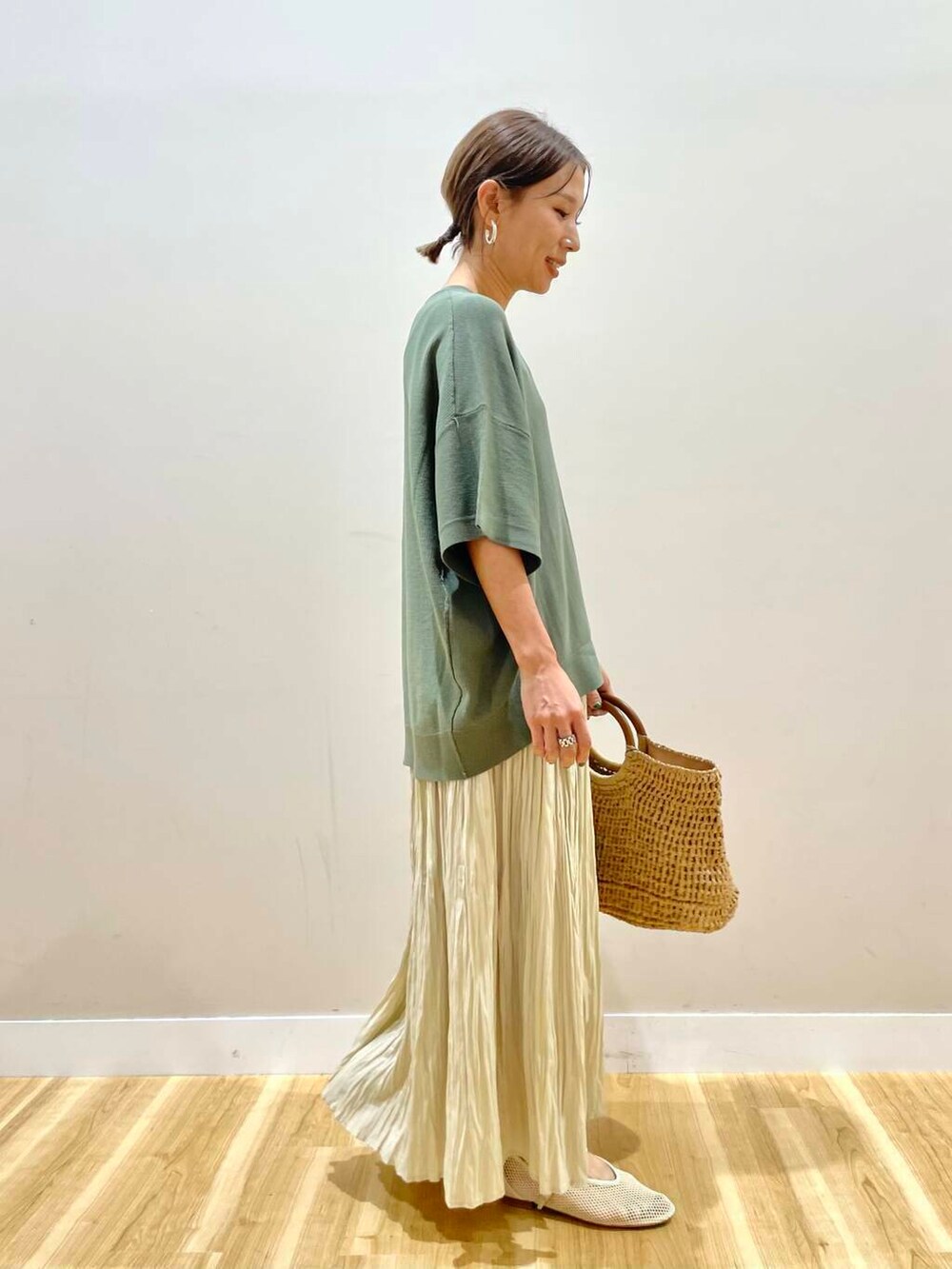 ベージュ系のトートバッグ、ベージュ系のスカート、ホワイト系のその他シューズを着用したレディースの夏コーディネートの2枚目の写真