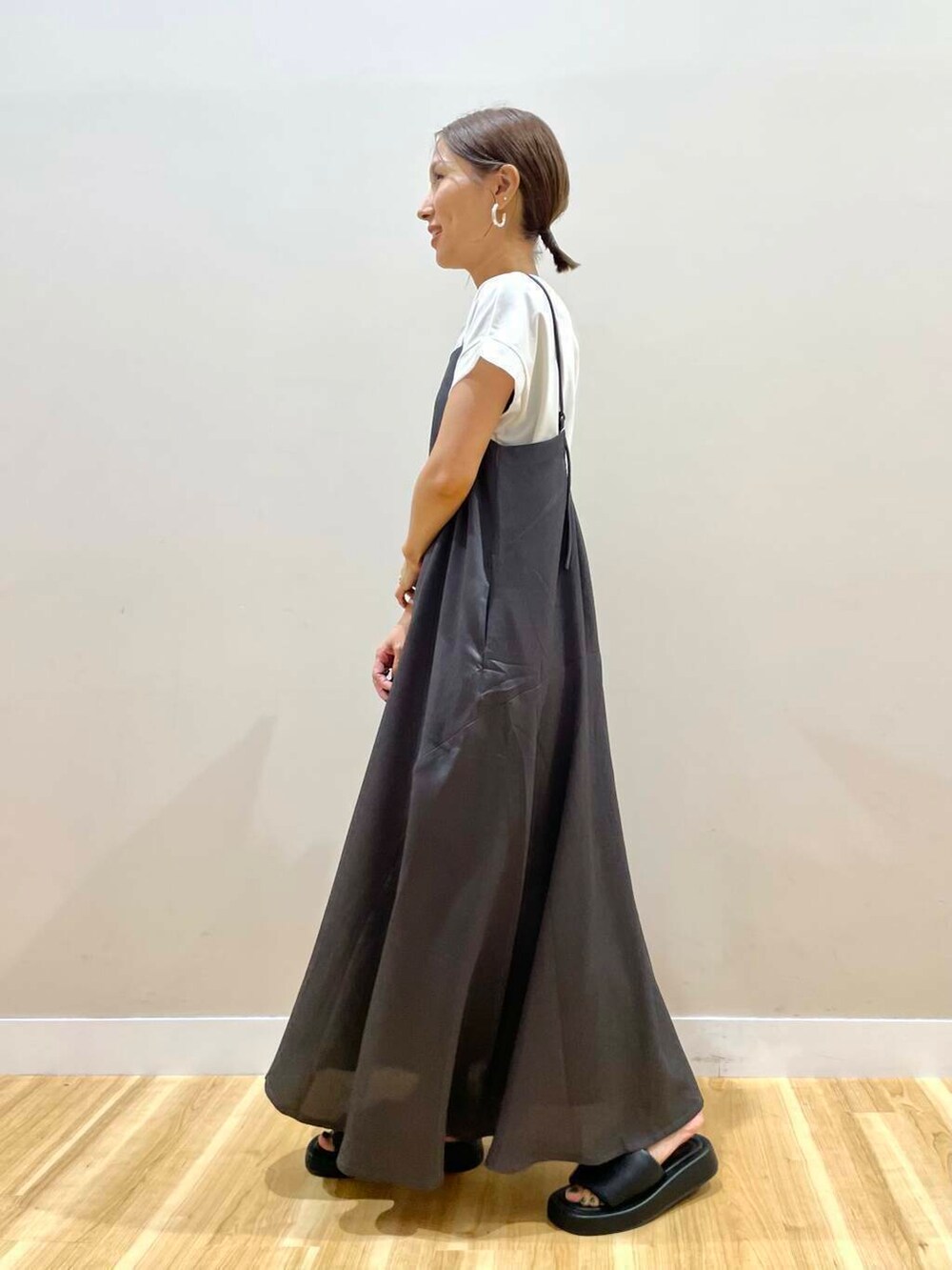 ブラック系のトートバッグ、ブラック系のサンダル、グレー系のワンピースを着用したレディースの夏コーディネートの4枚目の写真