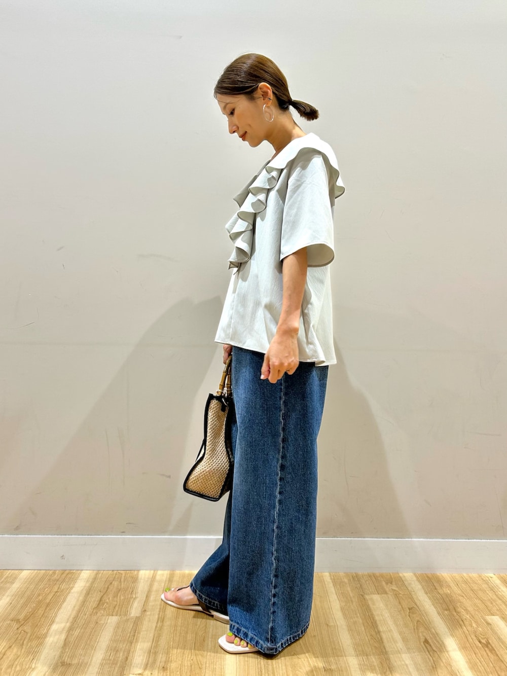 グレー系のシャツ/ブラウス、ブルー系のデニムパンツ、ブラック系のショルダーバッグを着用したレディースの夏コーディネートの3枚目の写真