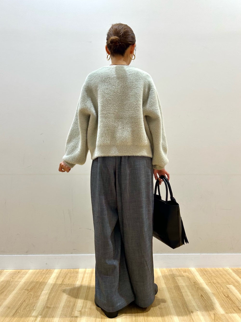 ベージュ系のニット/セーター、ブラック系のその他パンツ、ブラック系のトートバッグを着用したレディースの秋コーディネートの3枚目の写真