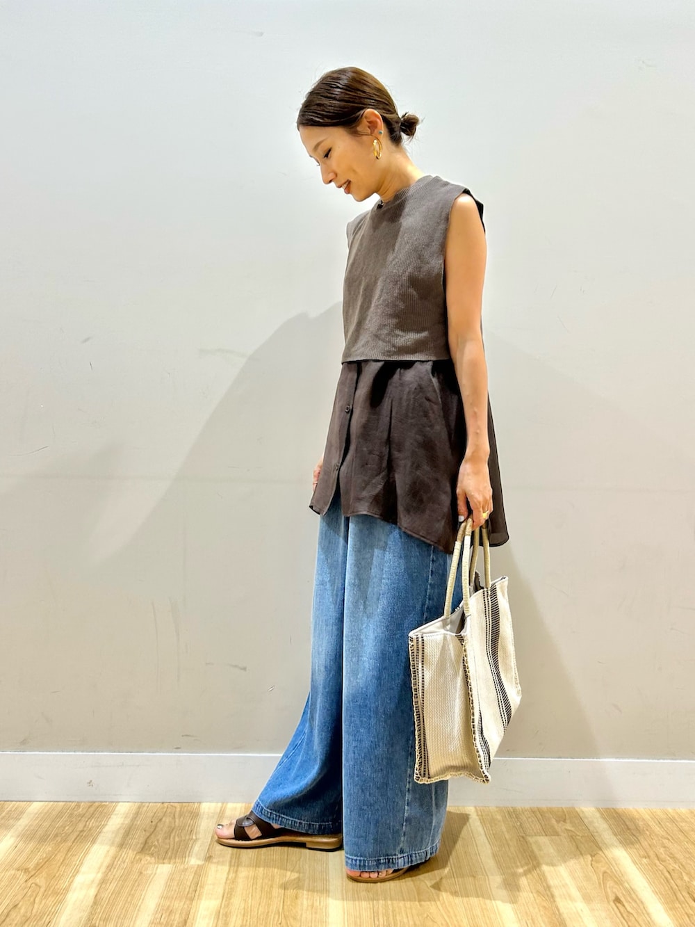 ブラウン系のシャツ/ブラウス、ブルー系のデニムパンツ、ホワイト系のトートバッグを着用したレディースの夏コーディネートの5枚目の写真