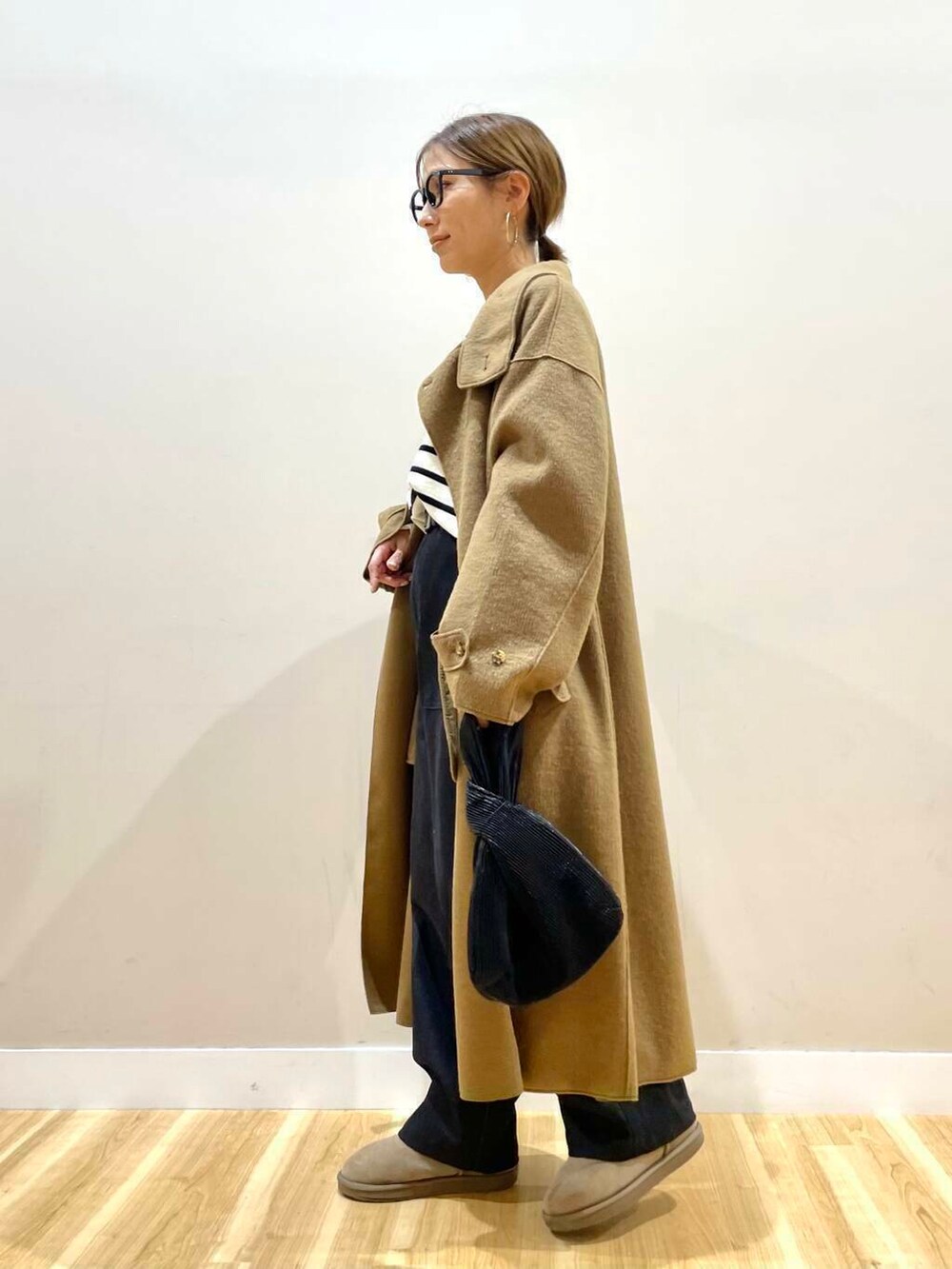 ブラック系のハンドバッグ、ブラック系のニット/セーター、ブラック系のデニムパンツを着用したレディースの秋コーディネートの3枚目の写真