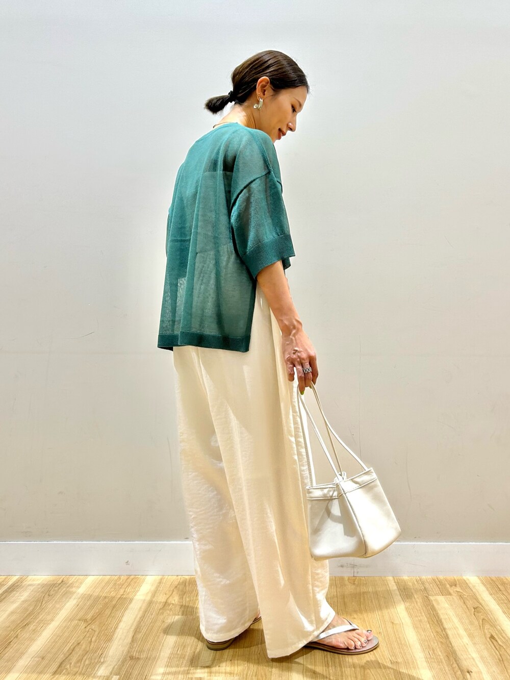グリーン系のニット/セーター、ホワイト系のその他パンツを着用したレディースの夏コーディネートの5枚目の写真