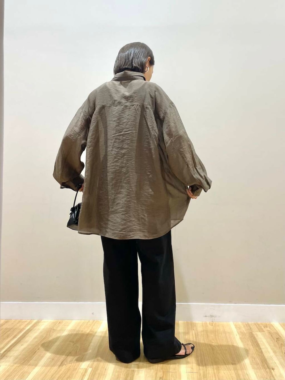 ブラック系のショルダーバッグ、ブラック系のタンクトップ、ブラウン系のシャツ/ブラウスを着用したレディースの秋コーディネートの3枚目の写真