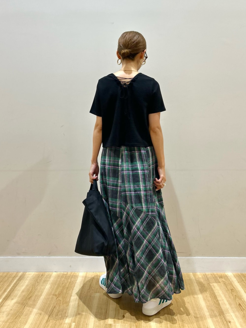 ブラック系のTシャツ/カットソー、グリーン系のスカート、ホワイト系のスニーカーを着用したレディースの夏コーディネートの3枚目の写真
