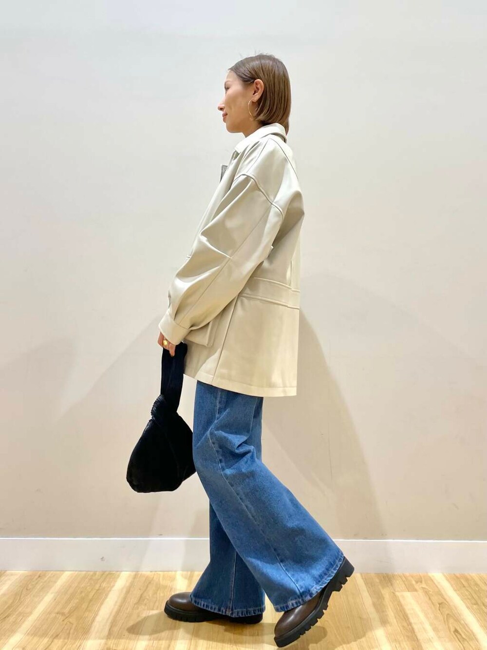 ブラウン系のブーツ、ブルー系のデニムパンツ、ブラック系のハンドバッグを着用したレディースの秋コーディネートの4枚目の写真