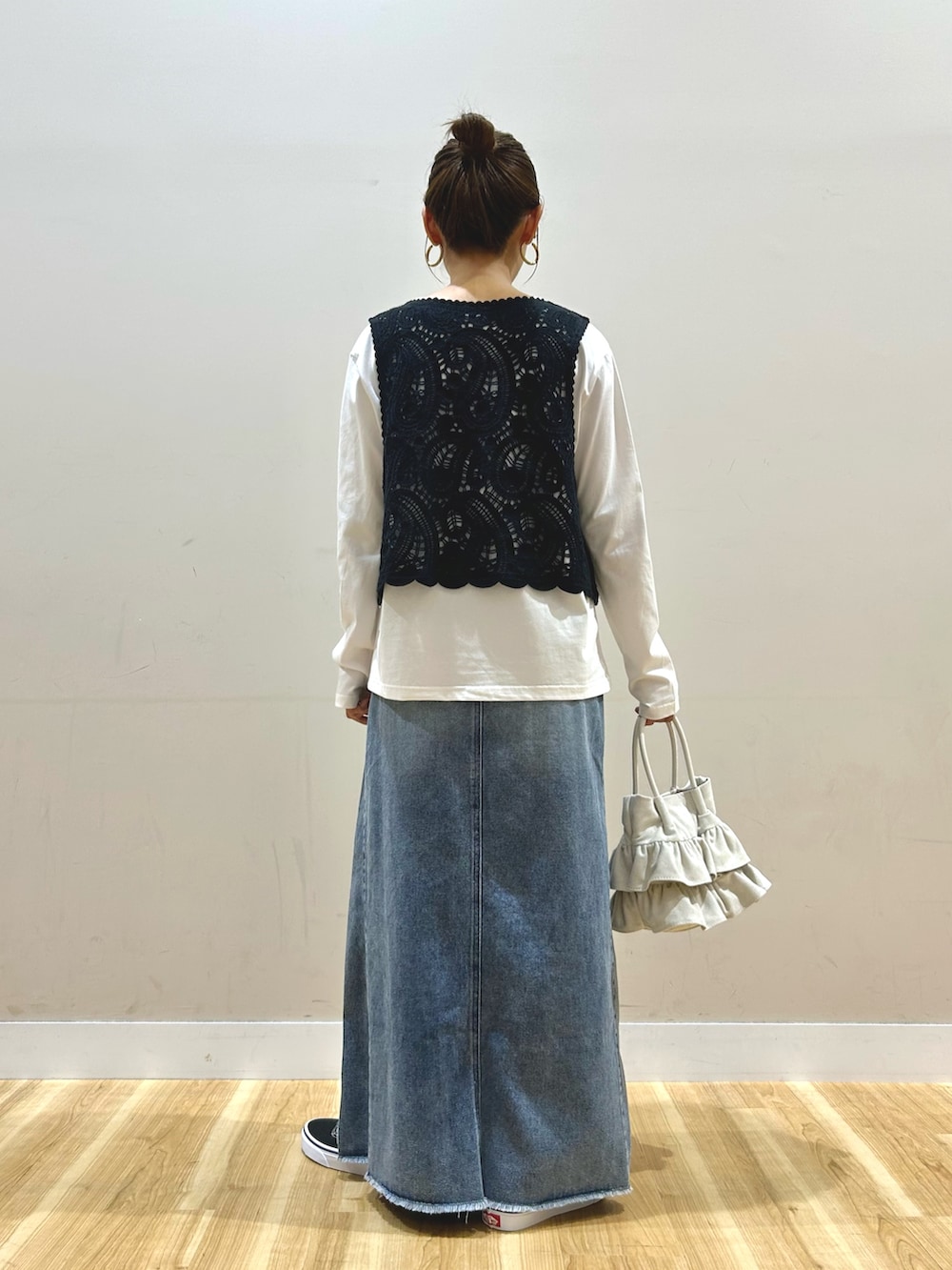 グリーン系のブルゾン、ブラック系のTシャツ/カットソー、ブルー系のスカートを着用したレディースの春コーディネートの6枚目の写真