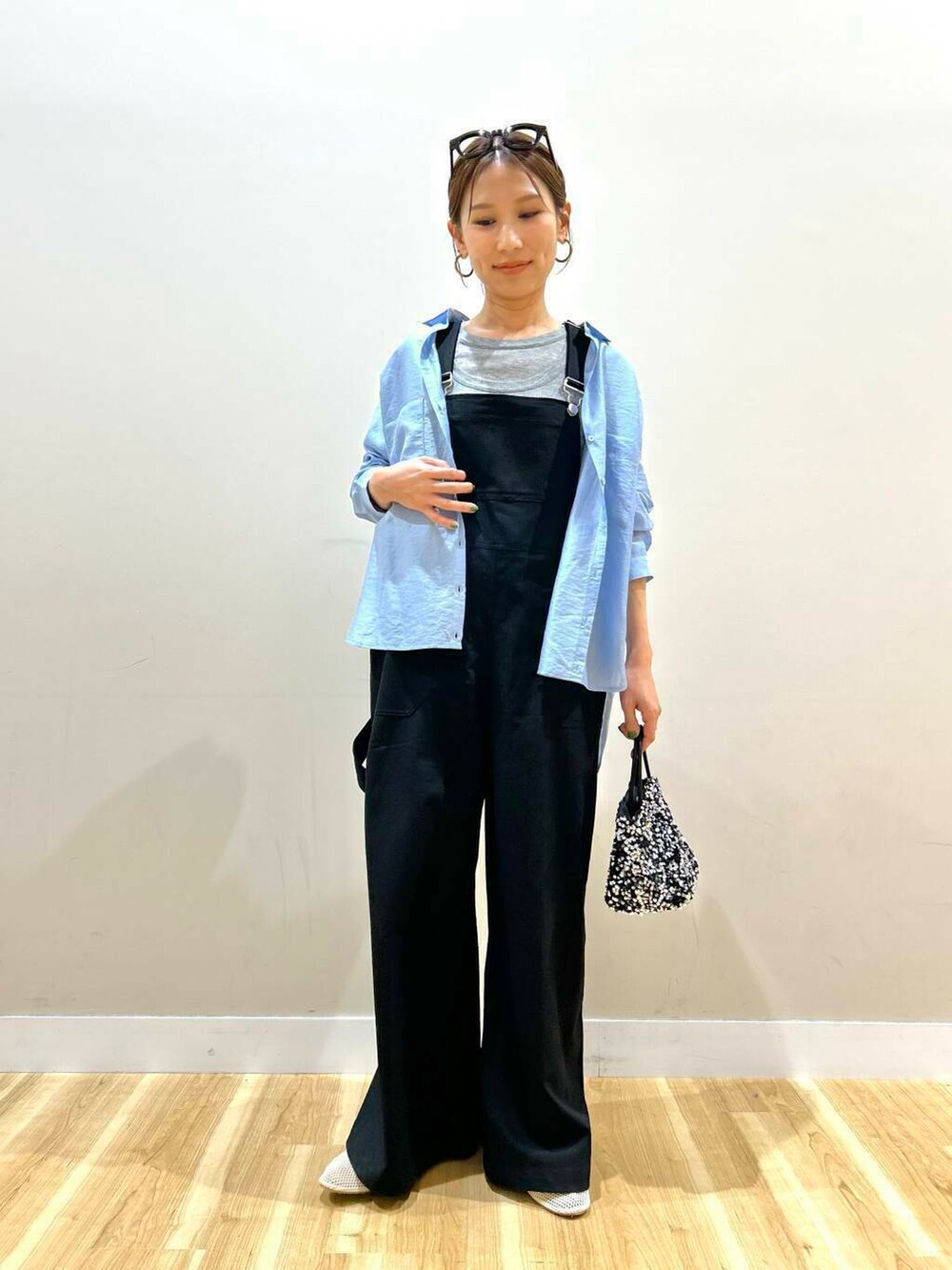 ブルー系のシャツ/ブラウス、シルバー系のショルダーバッグ、ブラック系のサロペット/オーバーオールを着用したレディースの春コーディネートの3枚目の写真