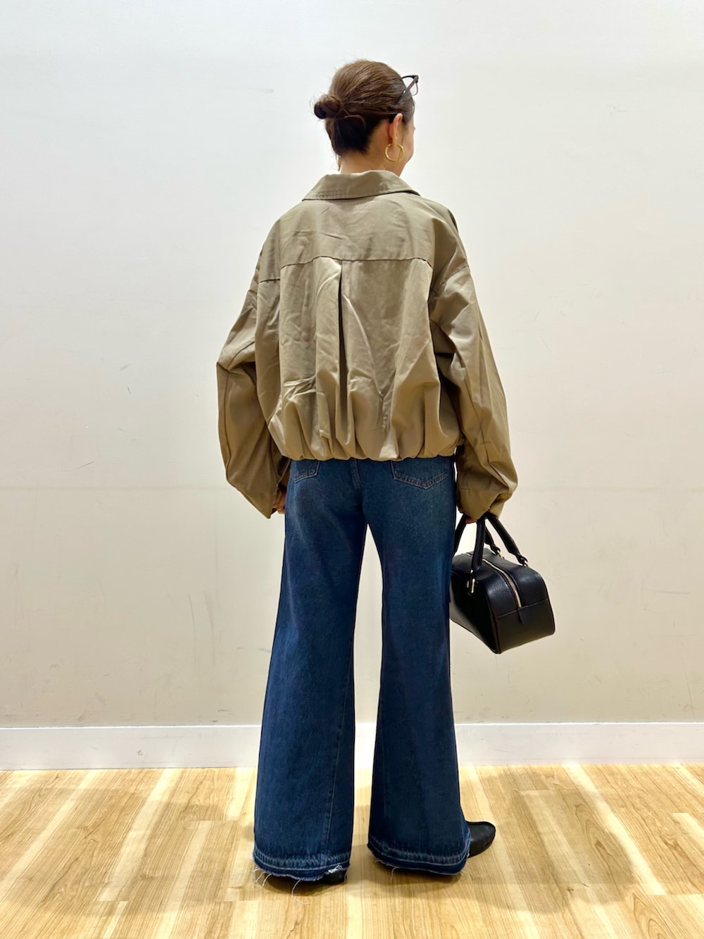 ベージュ系のブルゾン、ブルー系のTシャツ/カットソー、ブルー系のデニムパンツを着用したレディースの秋コーディネートの4枚目の写真