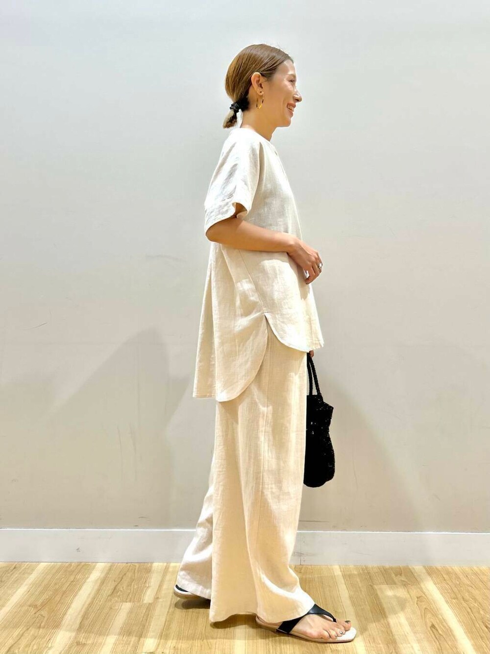 ベージュ系のその他パンツ、ベージュ系のシャツ/ブラウス、ブラック系のショルダーバッグを着用したレディースの夏コーディネートの4枚目の写真