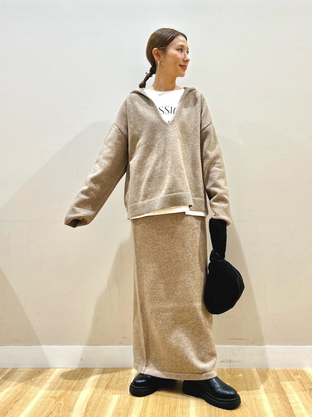 ベージュ系のニット/セーター、ホワイト系のTシャツ/カットソー、ホワイト系のダウンジャケット/コートを着用したレディースの秋コーディネートの4枚目の写真