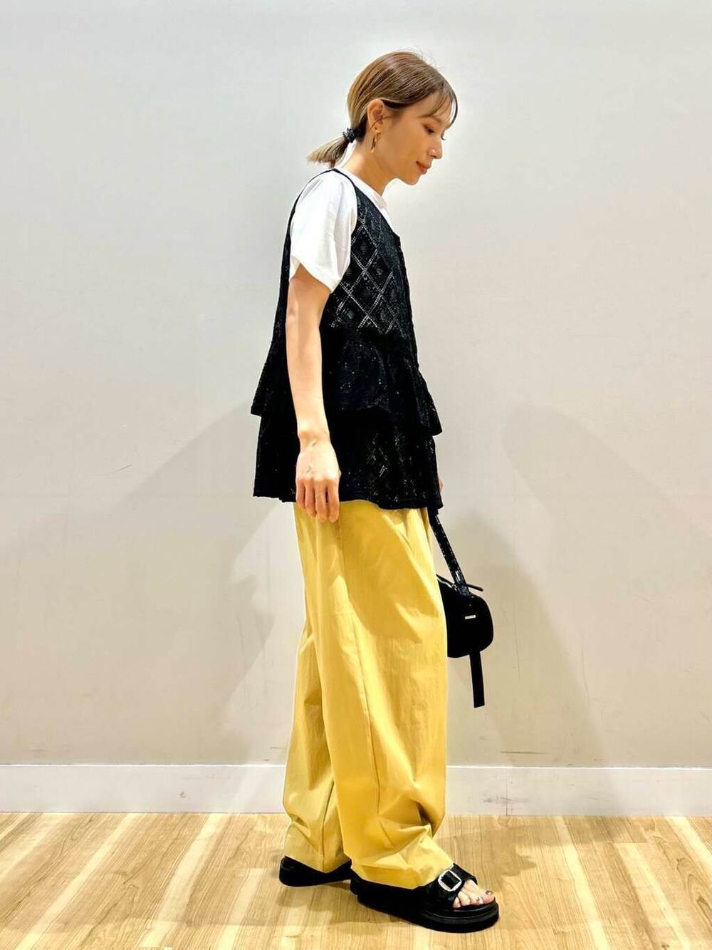 ブラック系のハンドバッグ、ベージュ系のその他パンツ、ホワイト系のTシャツ/カットソーを着用したレディースの夏コーディネートの2枚目の写真