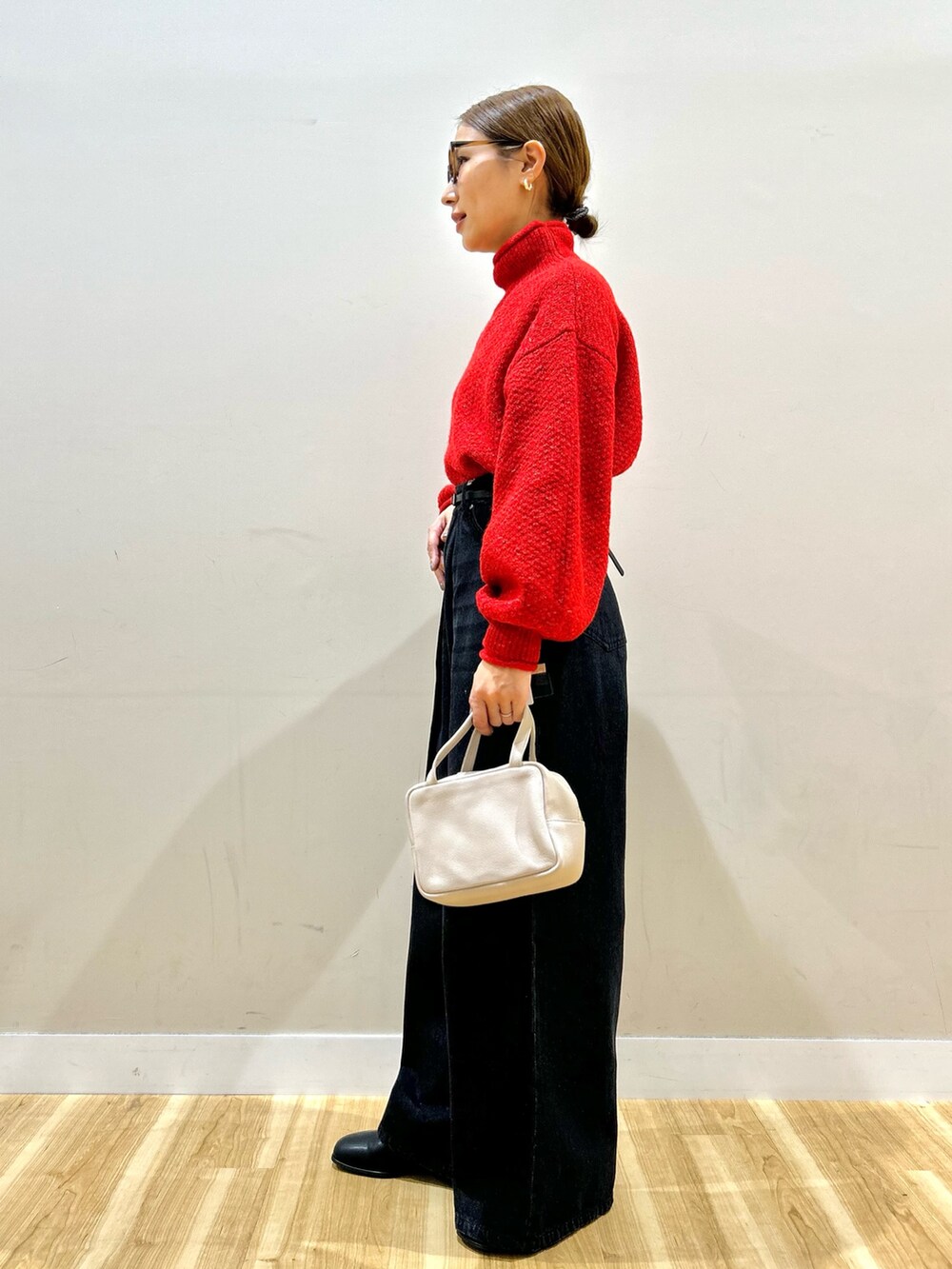 グレー系のその他アウター、レッド系のニット/セーター、ブラック系のデニムパンツを着用したレディースの冬コーディネートの6枚目の写真