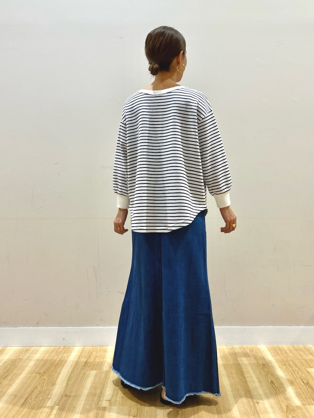 イエロー系のブルゾン、ホワイト系のTシャツ/カットソー、ブルー系のスカートを着用したレディースの春コーディネートの7枚目の写真