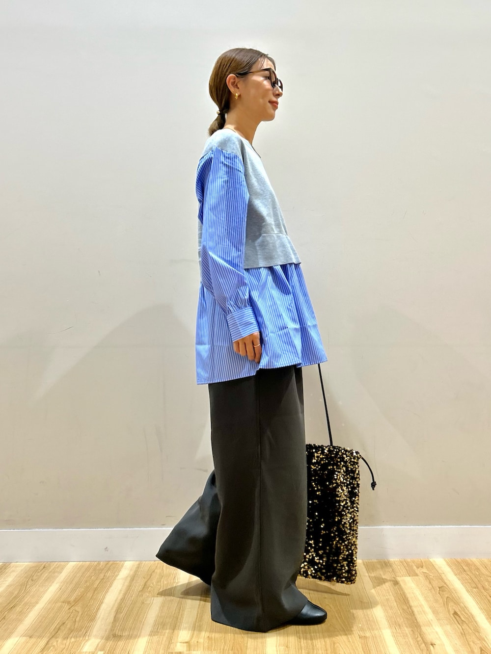 グレー系のニット/セーター、グレー系のその他パンツ、ゴールド系のトートバッグを着用したレディースの秋コーディネートの2枚目の写真