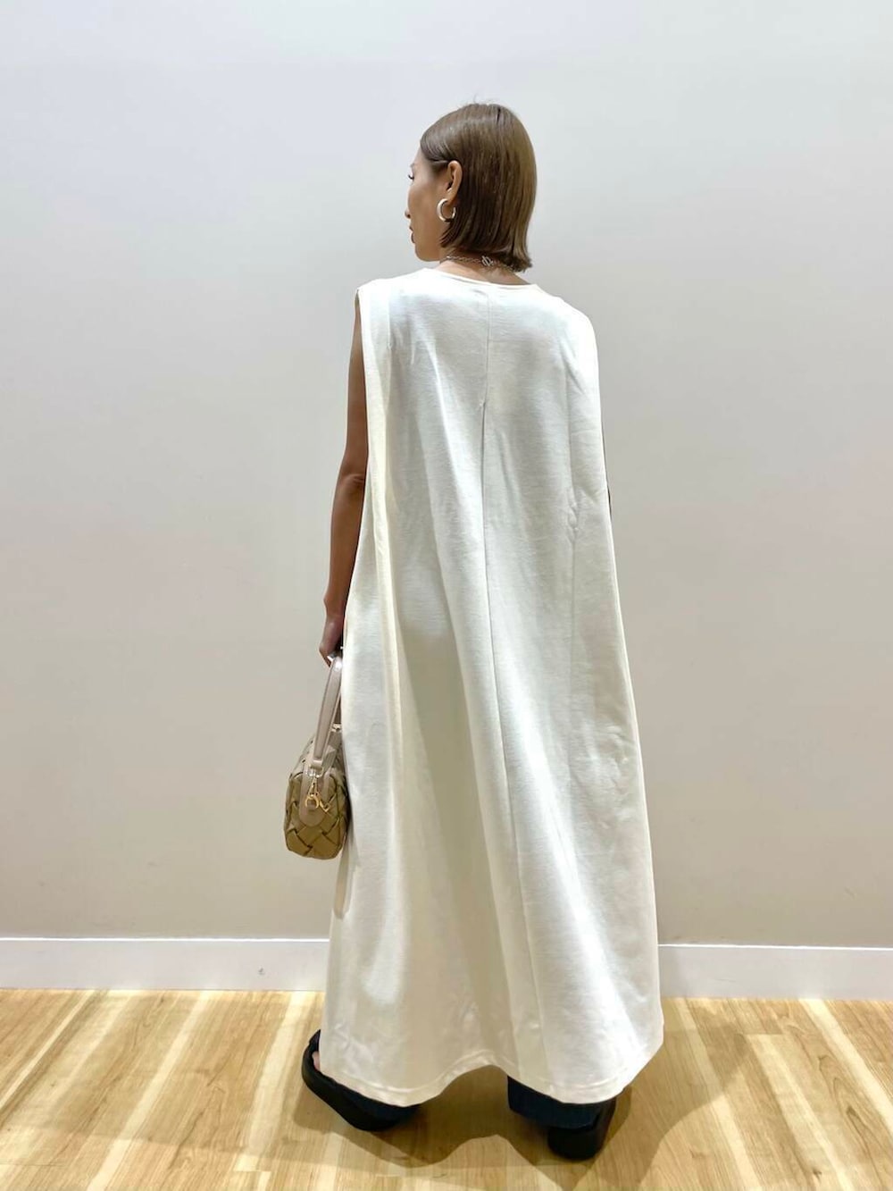 ブラック系のサンダル、ホワイト系のワンピース、ベージュ系のショルダーバッグを着用したレディースの夏コーディネートの3枚目の写真