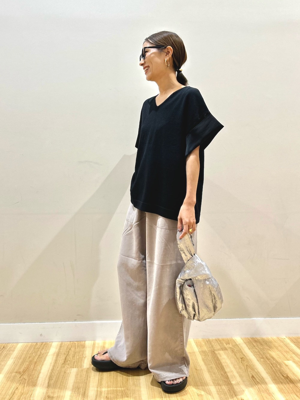 ブラック系のニット/セーター、グレー系のその他パンツ、シルバー系のハンドバッグを着用したレディースの秋コーディネートの2枚目の写真