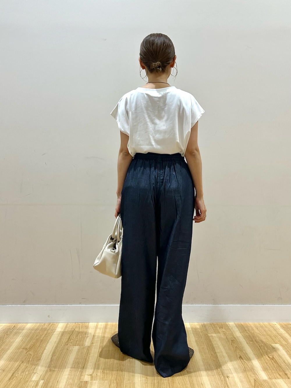 ホワイト系のTシャツ/カットソー、ブルー系のデニムパンツ、ブラウン系のハンドバッグを着用したレディースの春コーディネートの7枚目の写真