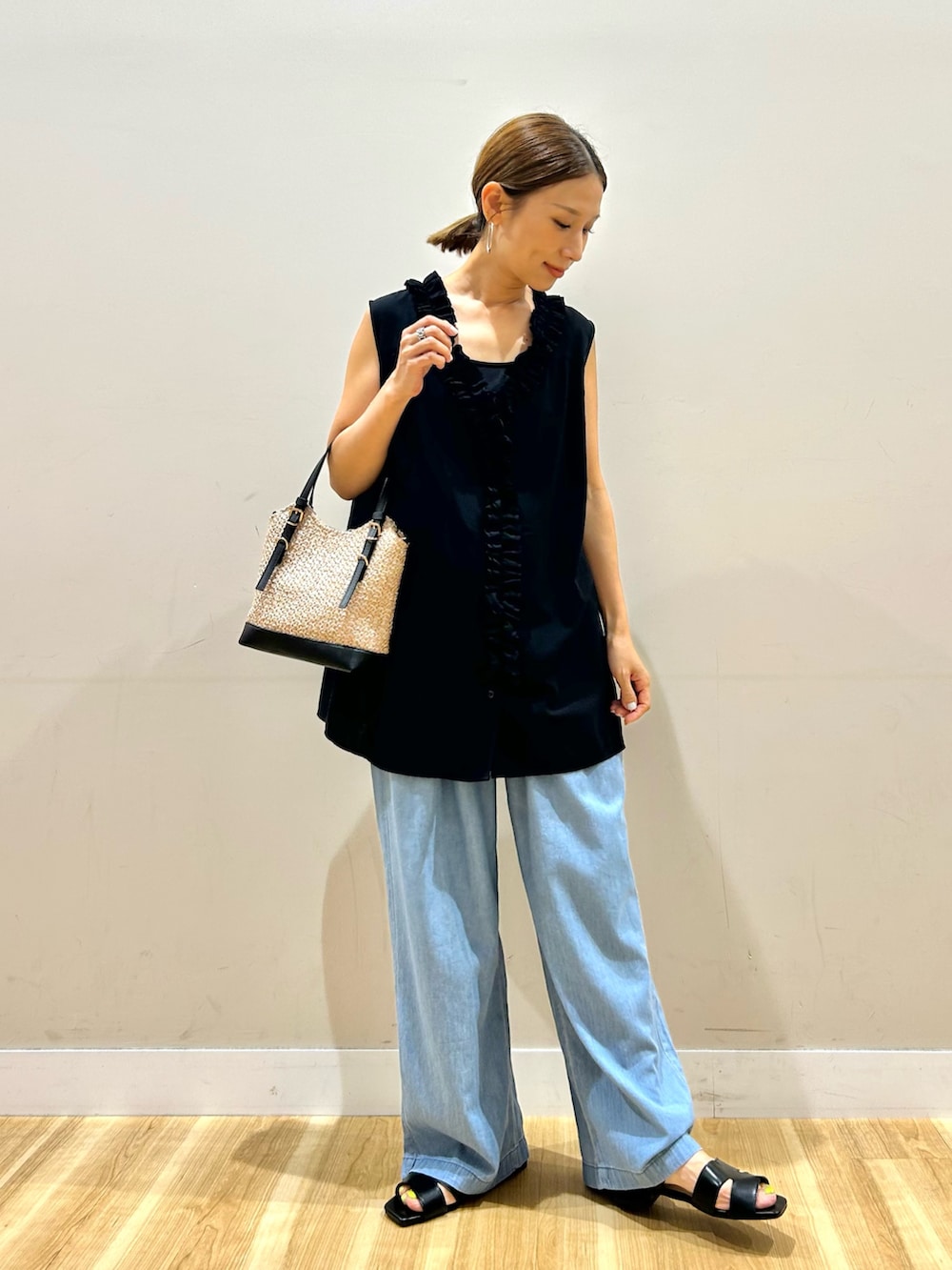 ブラック系のシャツ/ブラウス、ブルー系のデニムパンツ、ブラック系のショルダーバッグを着用したレディースの夏コーディネートの2枚目の写真