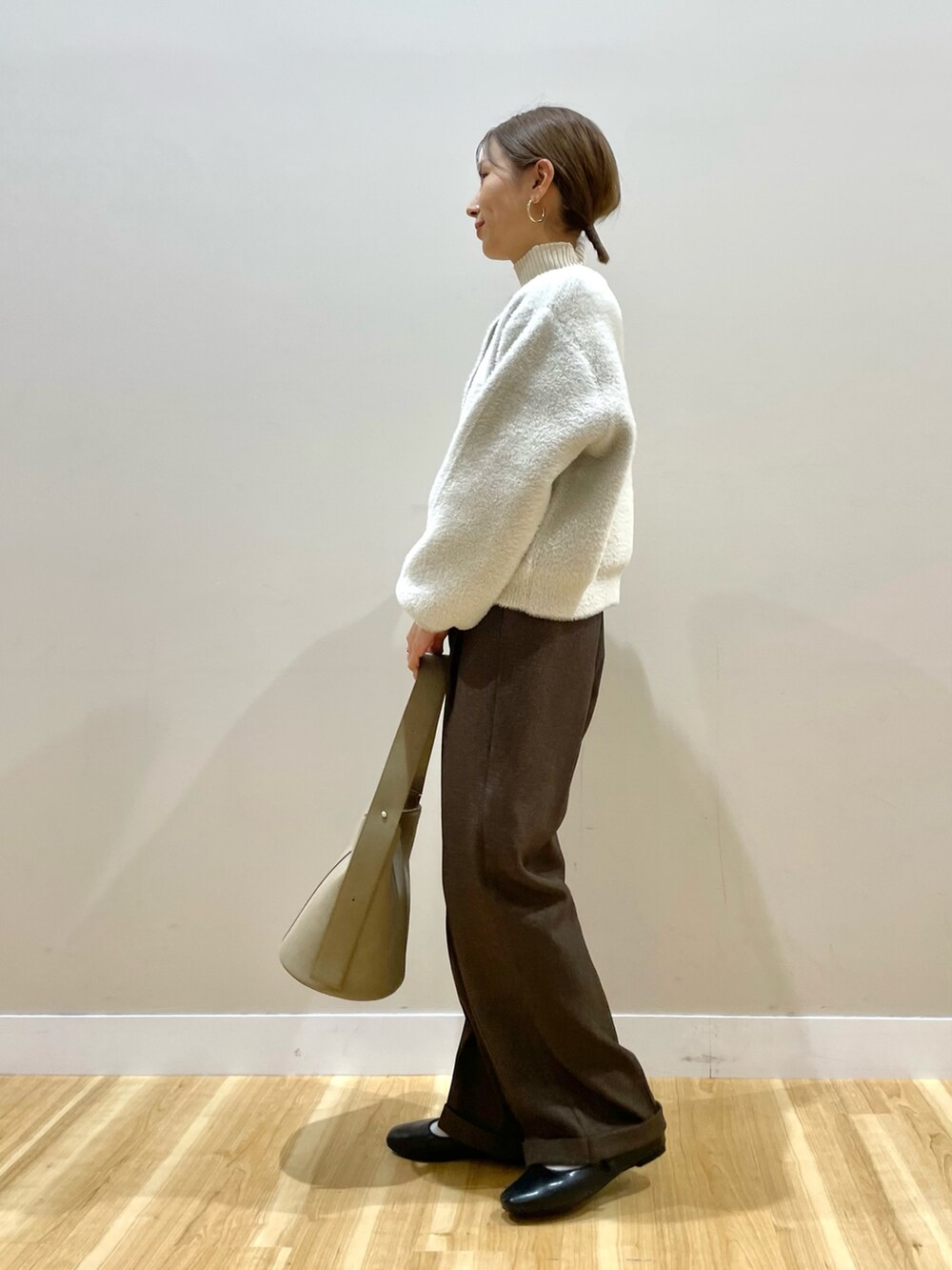 ホワイト系のカーディガン/ボレロ、ホワイト系のニット/セーター、ブラウン系のその他パンツを着用したレディースの冬コーディネートの2枚目の写真
