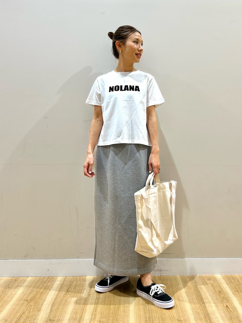 イエロー系のカーディガン/ボレロ、ホワイト系のTシャツ/カットソー、グレー系のスカートを着用したレディースの春コーディネートの4枚目の写真