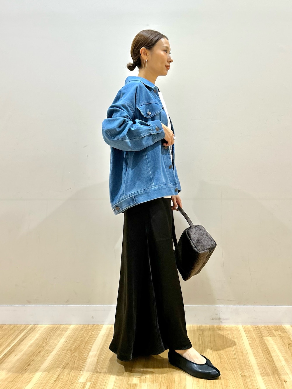 ブルー系のカバーオール、ホワイト系のTシャツ/カットソー、ブラック系のスカートを着用したレディースの秋コーディネートの2枚目の写真