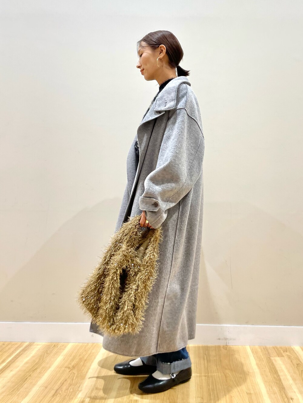 グレー系のその他アウター、ブラック系のニット/セーター、ブルー系のデニムパンツを着用したレディースの冬コーディネートの6枚目の写真