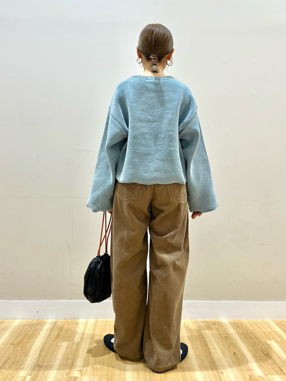 ブルー系のニット/セーター、ベージュ系のその他パンツを着用したレディースの秋コーディネートの3枚目の写真