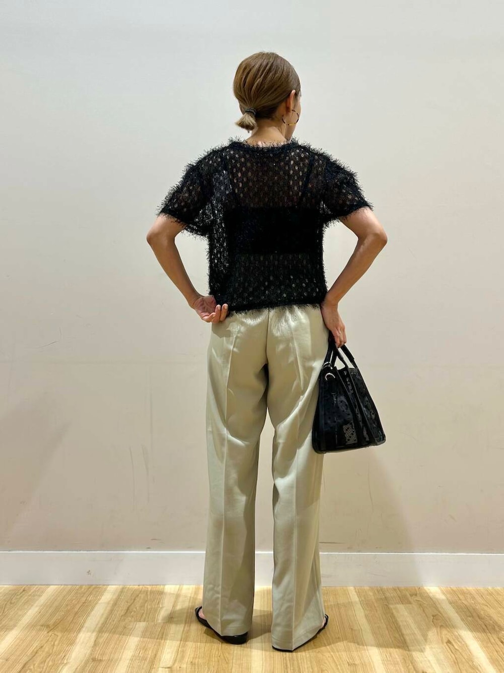 ブラック系のハンドバッグ、ブラック系のサンダル、ブラック系のTシャツ/カットソーを着用したレディースの夏コーディネートの3枚目の写真