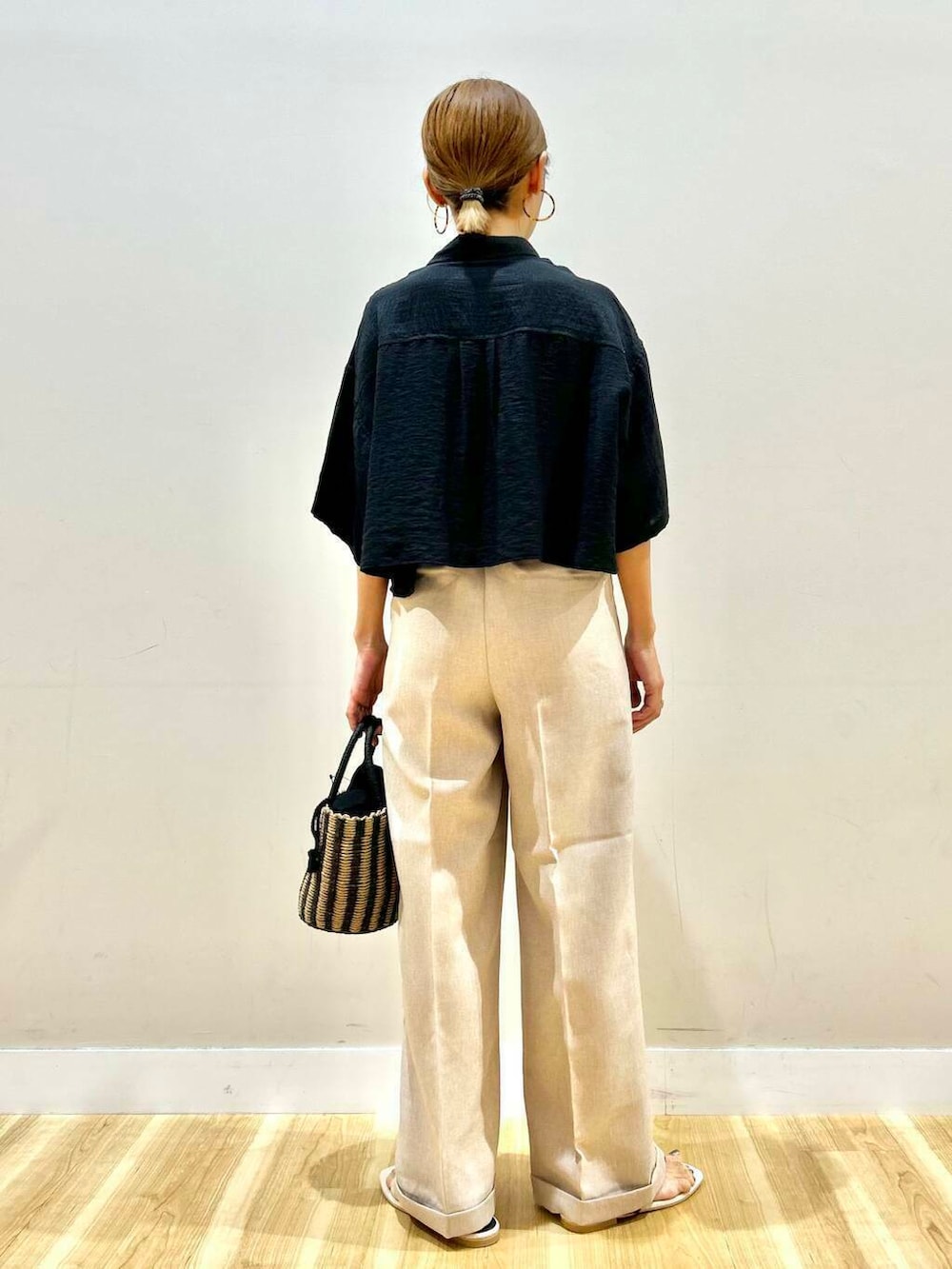 ブラック系のハンドバッグ、ブラック系のサンダル、ブラック系のシャツ/ブラウスを着用したレディースの夏コーディネートの3枚目の写真