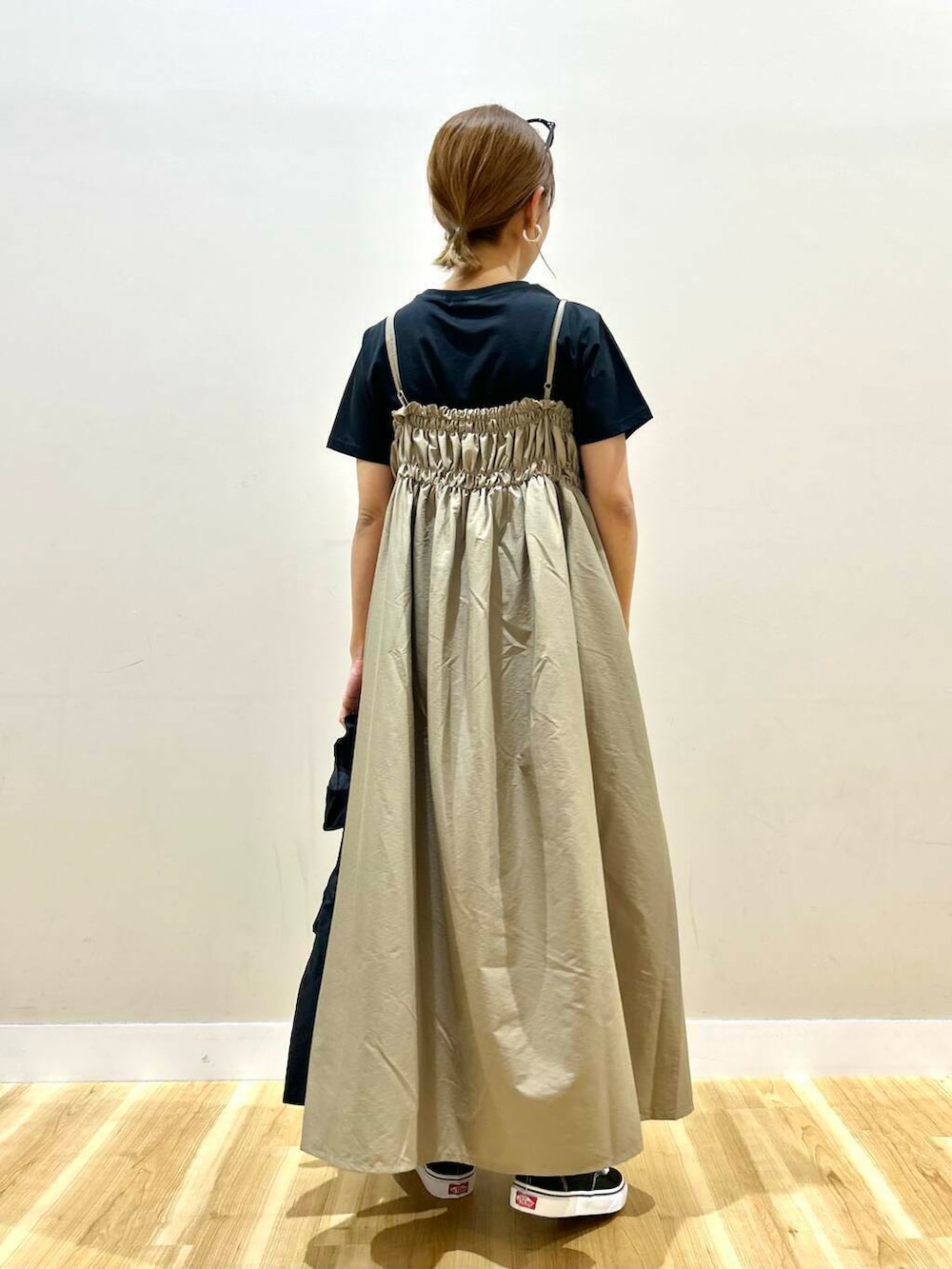 ブラック系のスニーカー、ブラック系のトートバッグ、ベージュ系のワンピースを着用したレディースの春コーディネートの4枚目の写真