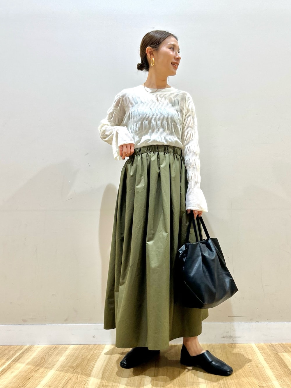 ホワイト系のカーディガン/ボレロ、ホワイト系のニット/セーター、グリーン系のスカートを着用したレディースの春コーディネートの4枚目の写真