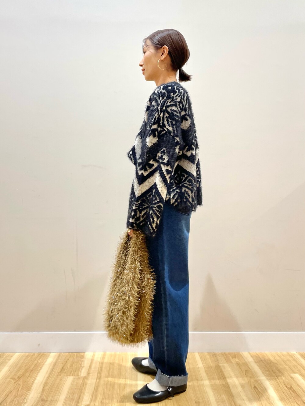 グレー系のその他アウター、ブラック系のニット/セーター、ブルー系のデニムパンツを着用したレディースの冬コーディネートの8枚目の写真