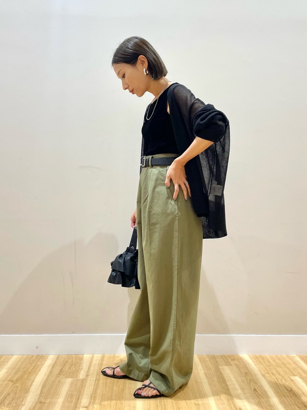 ブラック系のカーディガン/ボレロ、ブラック系のタンクトップ、グリーン系のチノパンツを着用したレディースの秋コーディネートの3枚目の写真