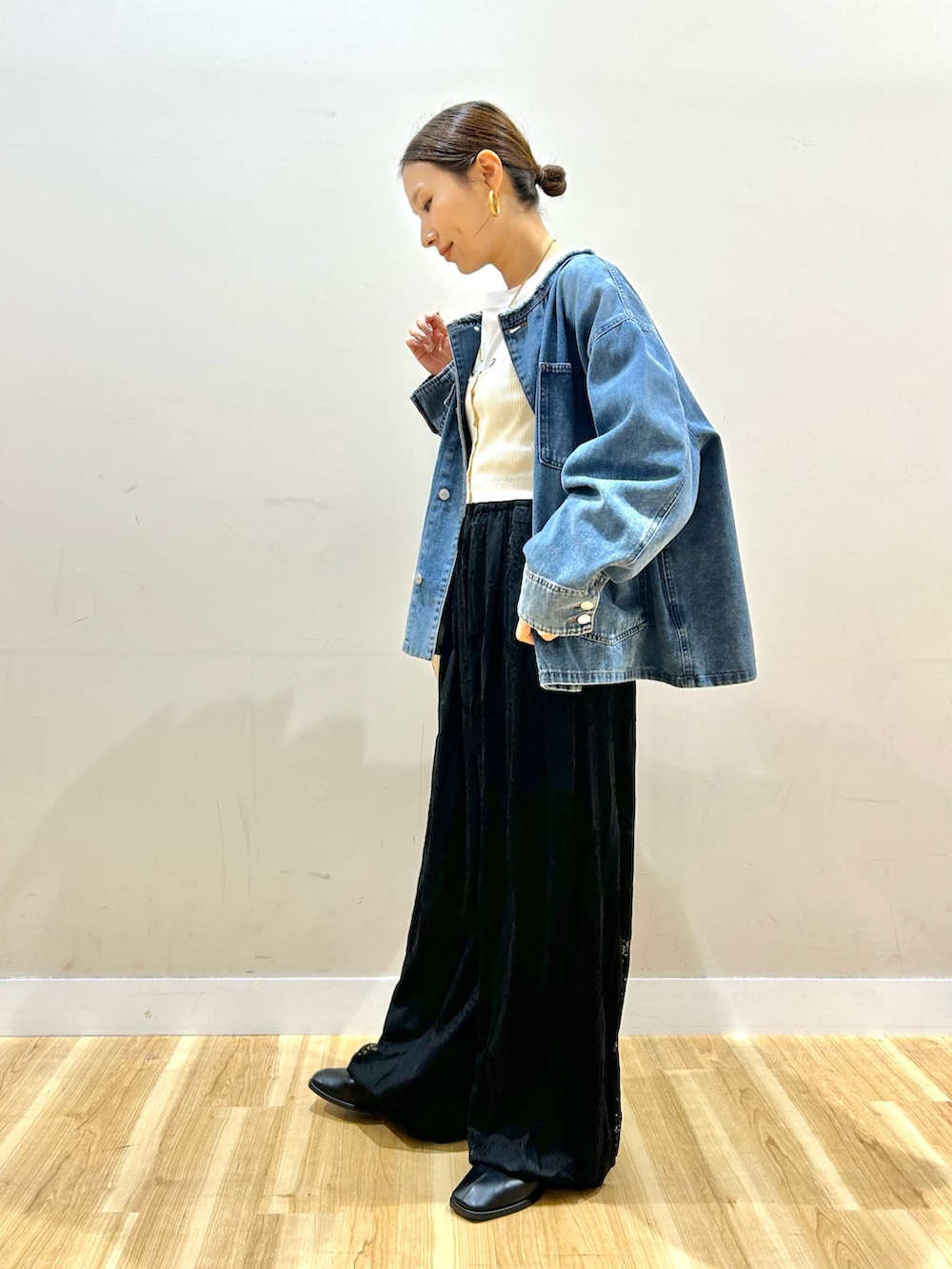 ブルー系のデニムジャケット、ホワイト系のベスト、ホワイト系のTシャツ/カットソーを着用したレディースの冬コーディネートの2枚目の写真