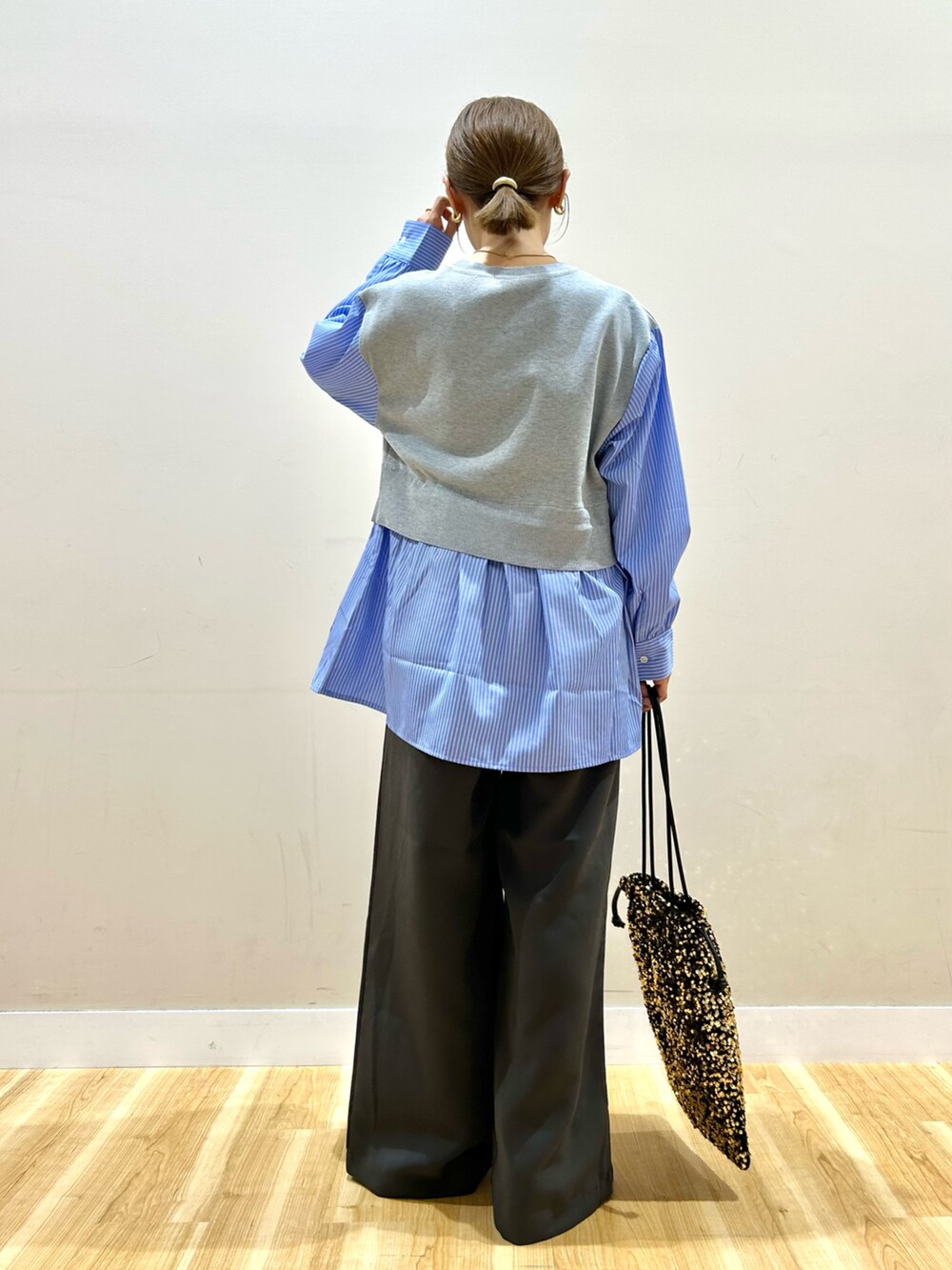 グレー系のニット/セーター、グレー系のその他パンツ、ゴールド系のトートバッグを着用したレディースの秋コーディネートの3枚目の写真