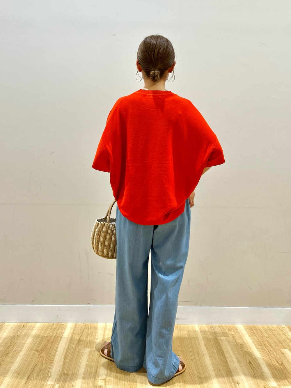 ブルー系のデニムパンツ、グレー系のハンドバッグ、ブラウン系のサンダルを着用したレディースの夏コーディネートの3枚目の写真