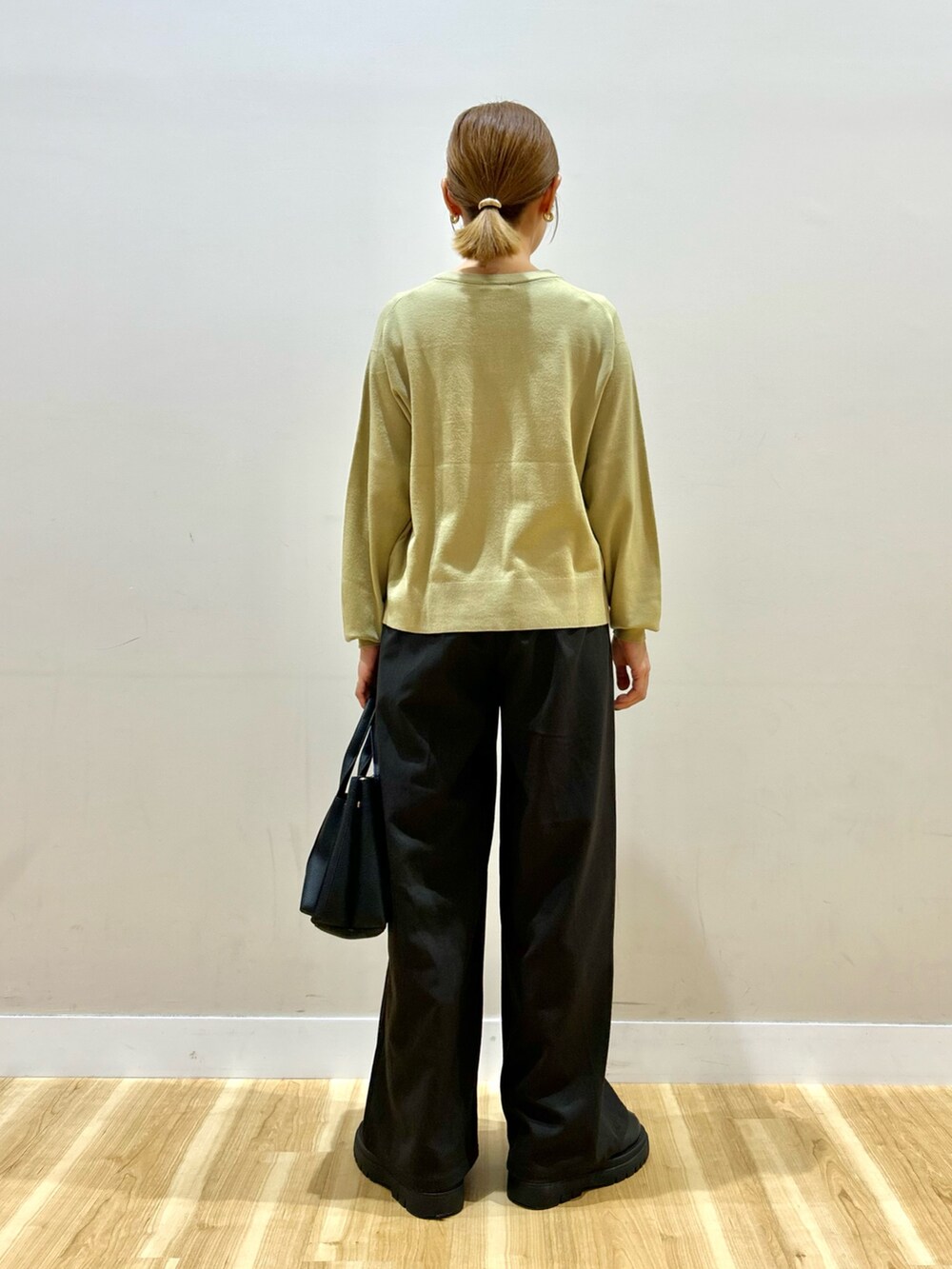 ブラック系のダウンジャケット/コート、グリーン系のカーディガン/ボレロ、ブラウン系のその他パンツを着用したレディースの秋コーディネートの7枚目の写真