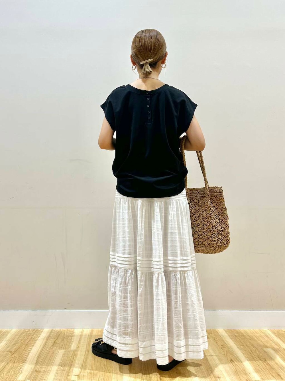 ブラック系のサンダル、ベージュ系のトートバッグ、ホワイト系のスカートを着用したレディースの夏コーディネートの4枚目の写真