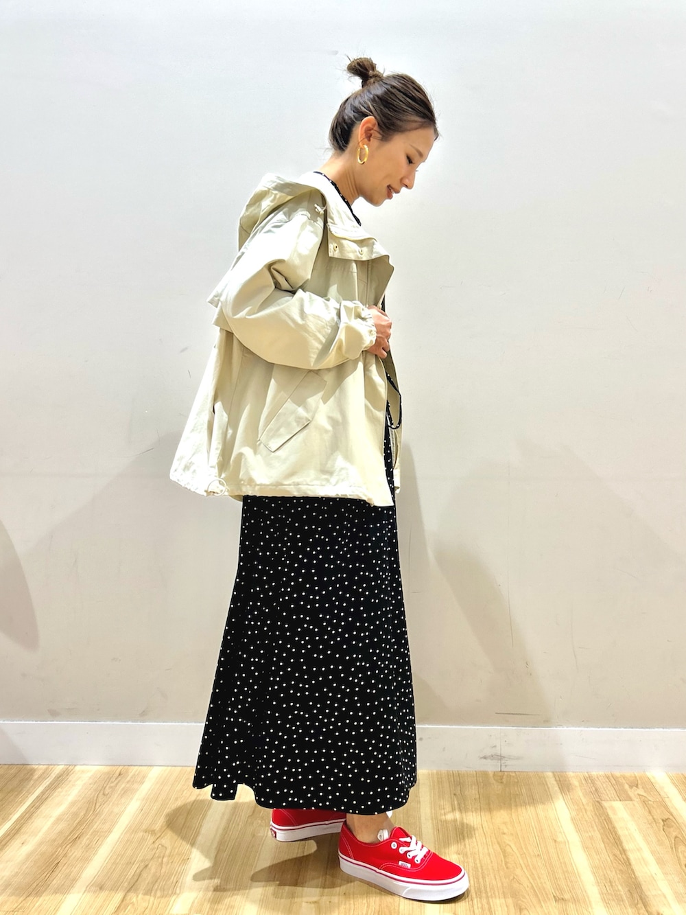 ホワイト系のマウンテンパーカー、ブラック系のワンピース、グリーン系のショルダーバッグを着用したレディースの春コーディネートの3枚目の写真