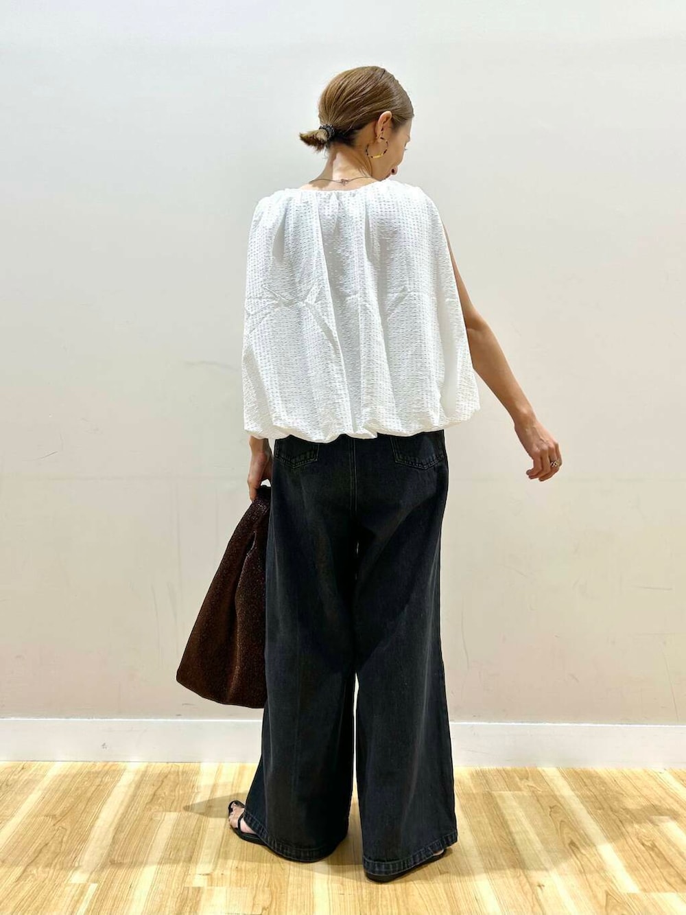 ブラウン系のトートバッグ、ブラック系のデニムパンツ、ホワイト系のシャツ/ブラウスを着用したレディースの夏コーディネートの4枚目の写真