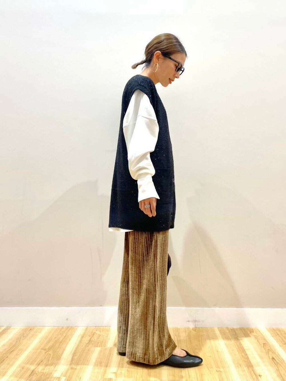 ブラック系のハンドバッグ、ホワイト系のTシャツ/カットソー、ブラウン系のその他パンツを着用したレディースの秋コーディネートの3枚目の写真