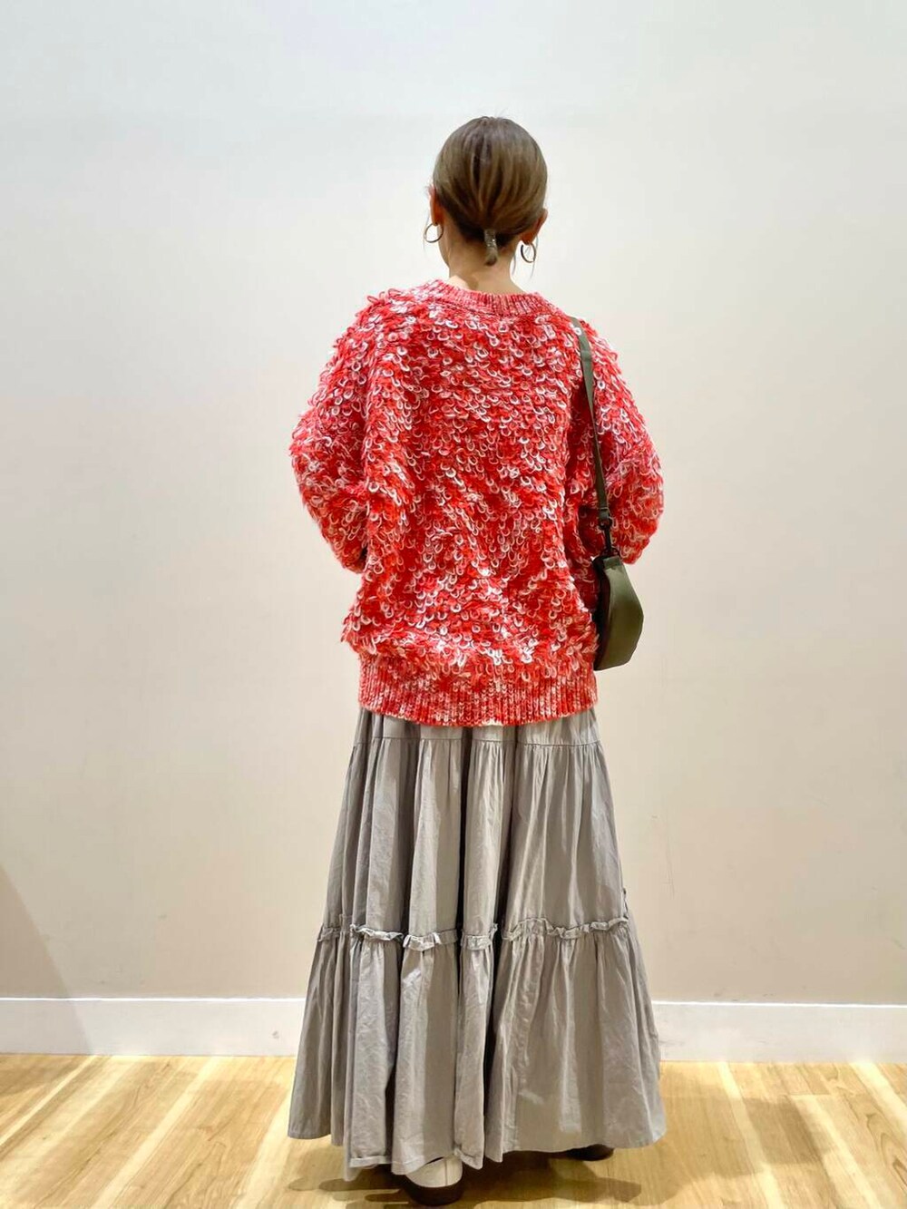 ブラック系のダウンジャケット/コート、グリーン系のショルダーバッグ、レッド系のニット/セーターを着用したレディースの冬コーディネートの7枚目の写真