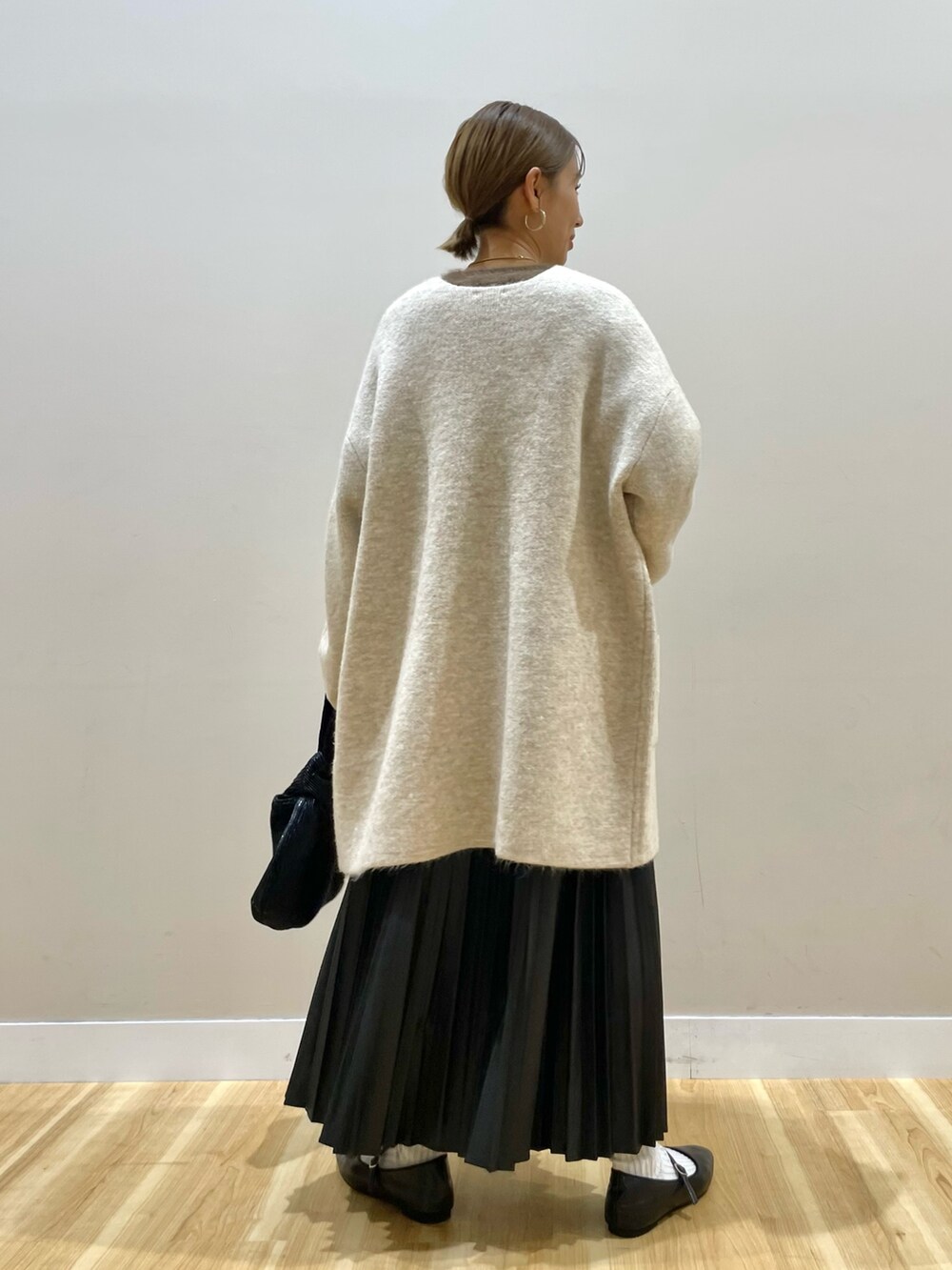 ベージュ系のカーディガン/ボレロ、ブラウン系のニット/セーター、ブラック系のスカートを着用したレディースの冬コーディネートの4枚目の写真