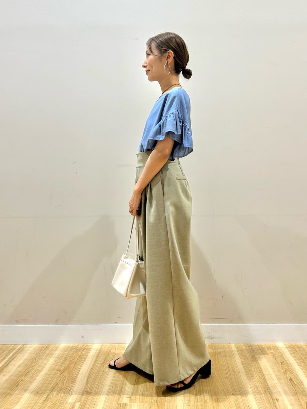 ブルー系のシャツ/ブラウス、ベージュ系のその他パンツ、ホワイト系のハンドバッグを着用したレディースの夏コーディネートの3枚目の写真