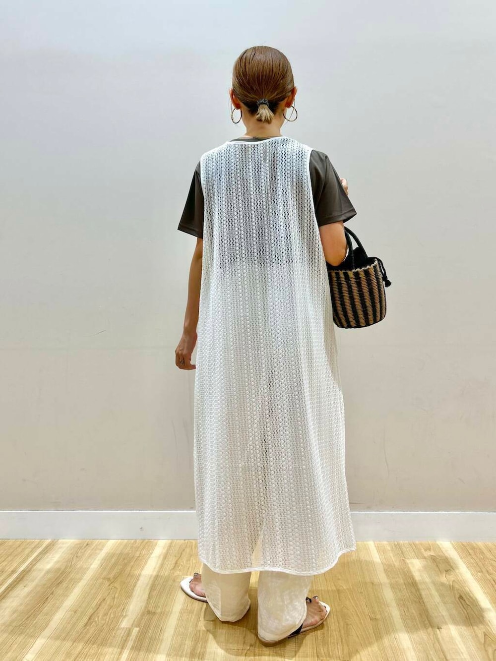 ブラック系のハンドバッグ、ブラック系のサンダル、ホワイト系のその他パンツを着用したレディースの夏コーディネートの3枚目の写真