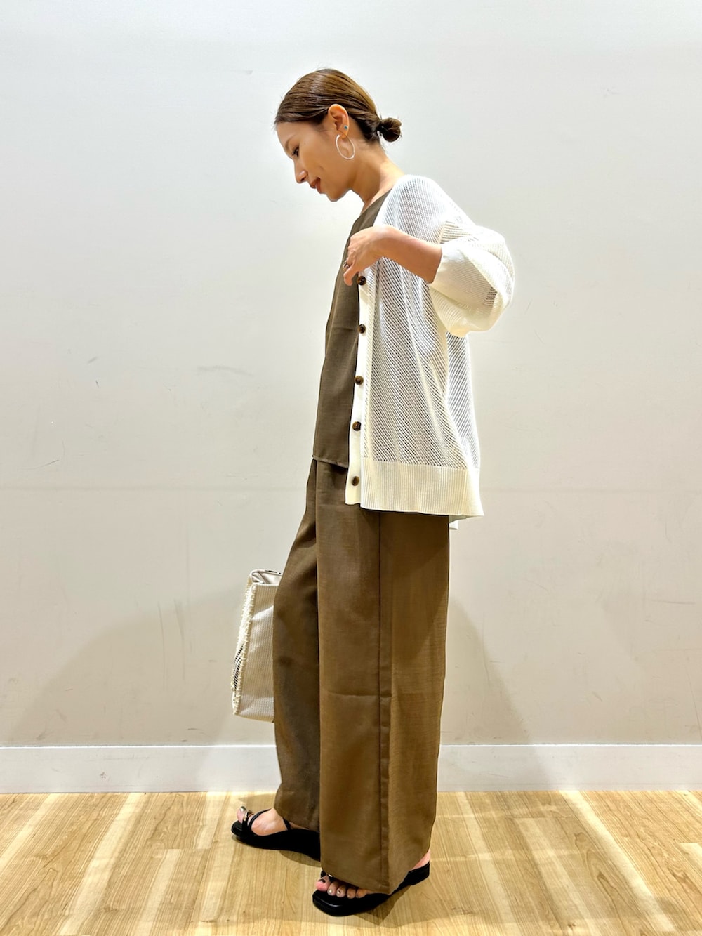 ホワイト系のニット/セーター、ブラウン系のセットアップ、ホワイト系のトートバッグを着用したレディースの夏コーディネートの2枚目の写真