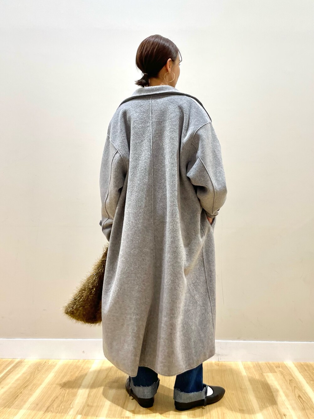 グレー系のその他アウター、ブラック系のニット/セーター、ブルー系のデニムパンツを着用したレディースの冬コーディネートの7枚目の写真