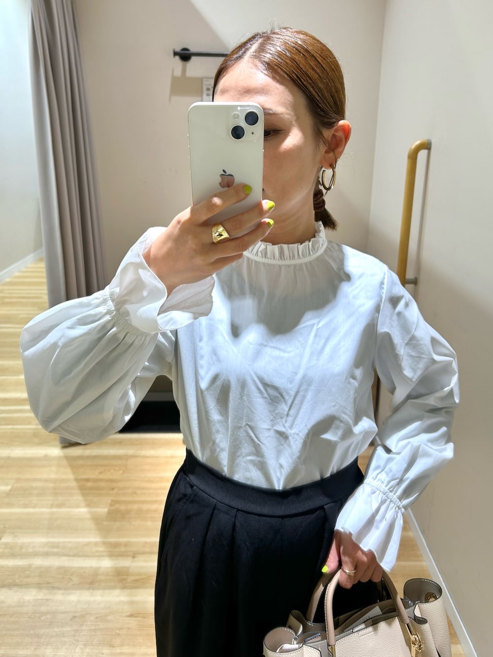 ブラック系のセットアップ、ホワイト系のトートバッグを着用したレディースの秋コーディネートの5枚目の写真